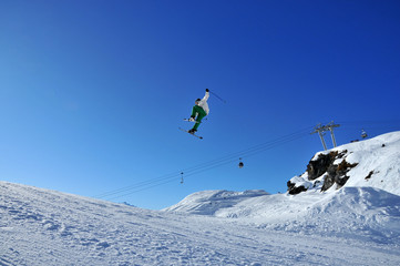 Naklejka na ściany i meble Aeroski: skier touching his ski during jump