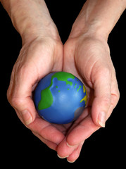 Earth in hands over black background