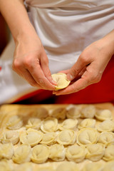 Woman making russian dumplings (pelmeni)