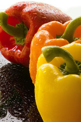 Three Bell Peppers on wet black surface