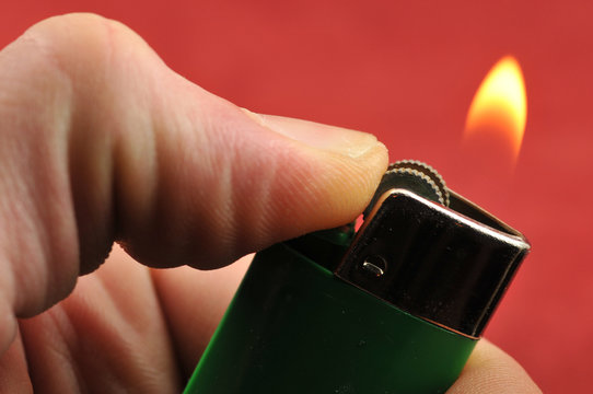 A hand holding out a cigarette lighter