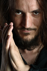 Young man praying and looking into camera