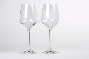 Two empty wine glasses on white background with copy space.