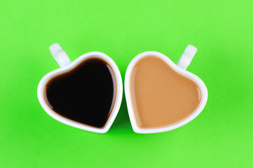 two heart shape cups on green background