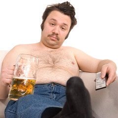 Overweight man on the couch with a beer glass