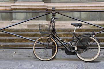 Old bicycle tied to a fence