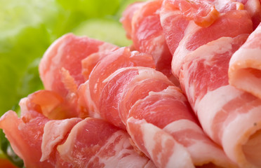 Sliced pork with bacon, lettuce and herbs