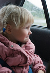 Little girl looks in automobile window