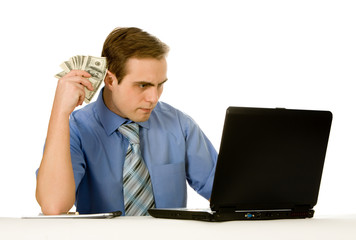 Businessman working on a laptop holding money. Isolated on white