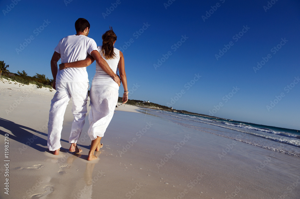 Wall mural couple walking on beach