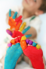Happy child with painted feet and hands