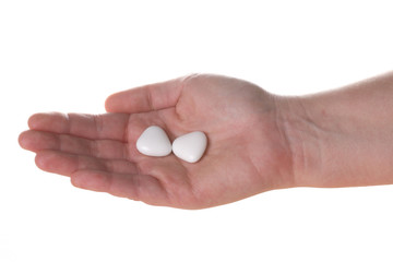 mano con due confetti a forma di cuore