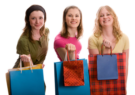 Three beautiful girls with shopping bags. Isolated on white