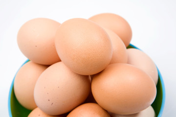 Photo of bowl with many brown hen eggs