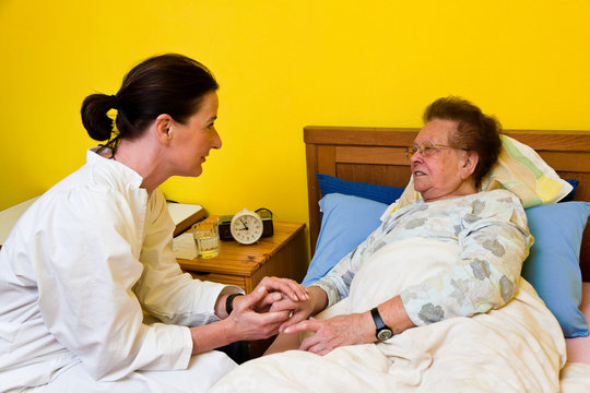 Pfleger betreut alte Frau im Altersheim
