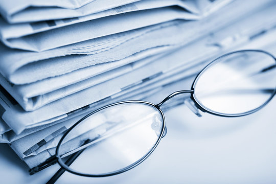 newspapers and glasses toned blue
