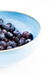 A bowl of fresh blueberries high contrast on white