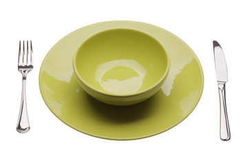 Green plate with tablewares on white background
