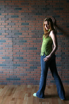 Attractive Young Woman Turned Away From Brick Wall