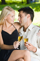 Young happy couple celebrating with champagne, outdoors