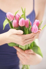Beautiful hands holding tulips. Soft-focused.