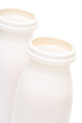 Two jars with milk over white