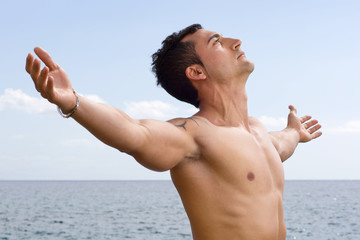 Modelo masculino con los brazos abiertos hacia el cielo