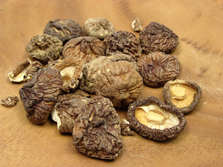 Getrocknete Shiitake Pilze auf braunem Holzbrett arrangiert