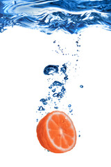 grapefruit dropped into water with bubbles isolated on white