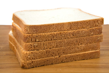 Slices of fresh sandwich bread on wooden board.