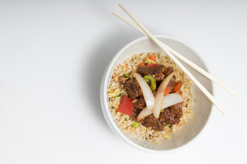 Bowl of fried rice topped with chicken and vegetables