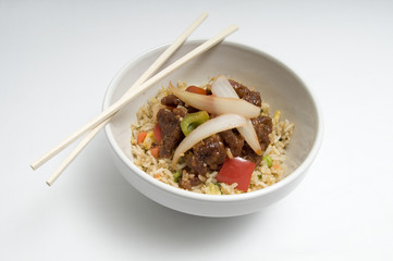 Bowl of fried rice topped with chicken and vegetables