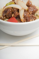 Bowl of fried rice topped with chicken and vegetables