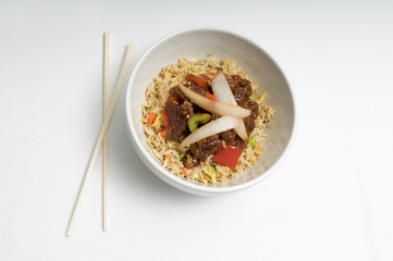Bowl of fried rice topped with chicken and vegetables