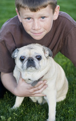 Young boy with his pet pug