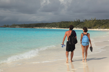 Two lovers walking in love on tropical island paradise beach