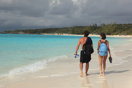 Two lovers walking in love on tropical island paradise beach