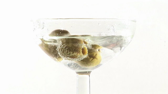 Martini cocktail with olives falling down footage