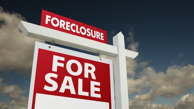 Foreclosure Home for Sale Sign with Dramatic Time-Lapse Clouds