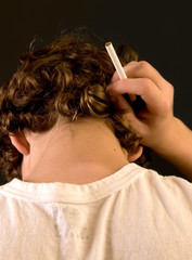 Obraz premium Teen smoker - closeup of back of head, with cigarette