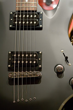 Black electric guitar with strings close-up