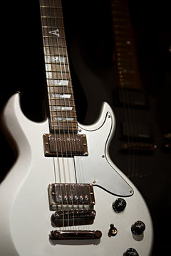 Silver and black guitars on a black background
