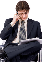 young businessman looks documents and calling by cellular phone