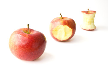 Three juicy gala apples in different stages of being eaten