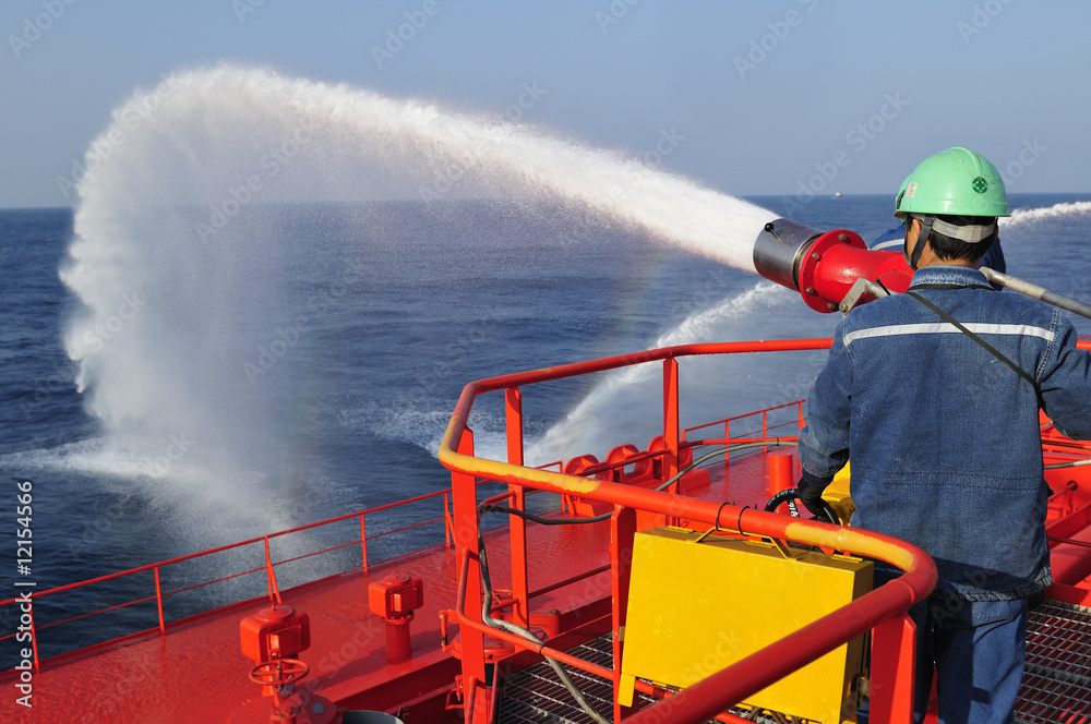 Wall mural Fireman testing a foam/water gun