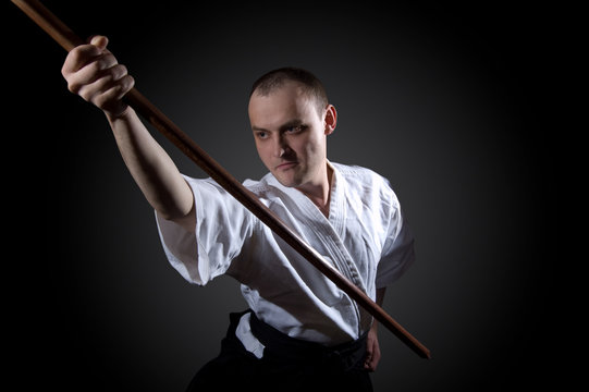 Man in white with wooden sword
