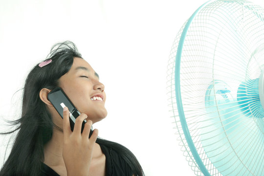 Woman Relaxing On Table With Electric Fan