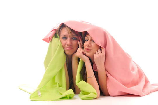 young girls under blanket smile