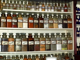Rows of old jars with dry herbs, lined up on the shelves