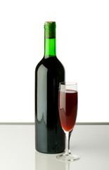Bottle and wine glass on reflective background